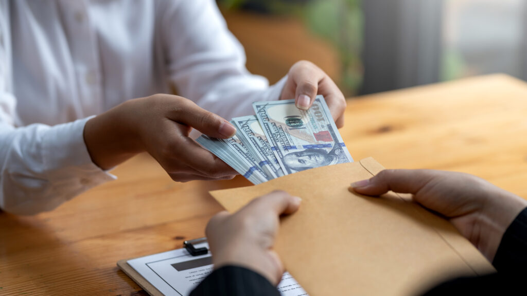 Person handing over cash during a no income verification home loans process